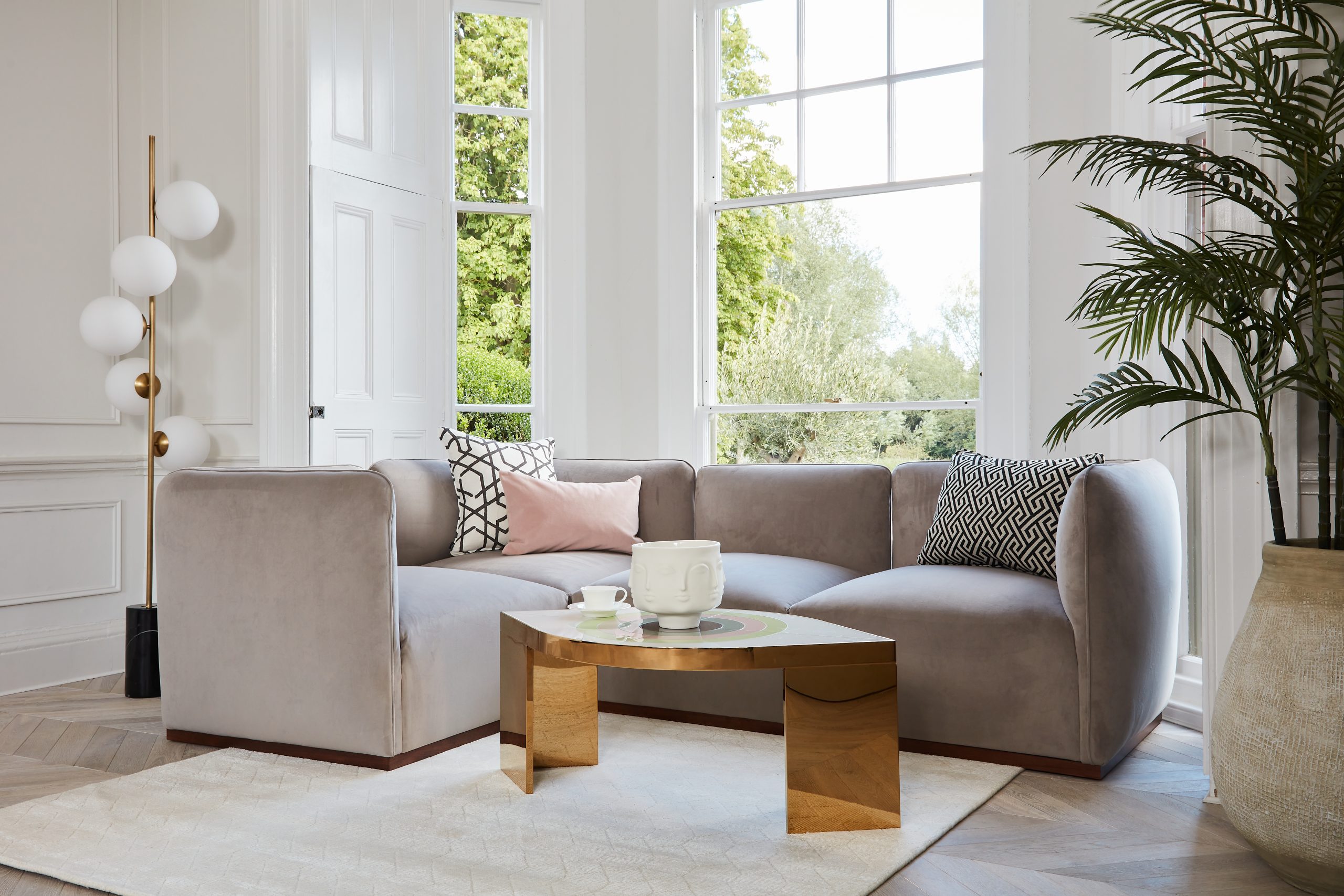 A beautiful grey velvet sofa in a living room lifestyle shot
