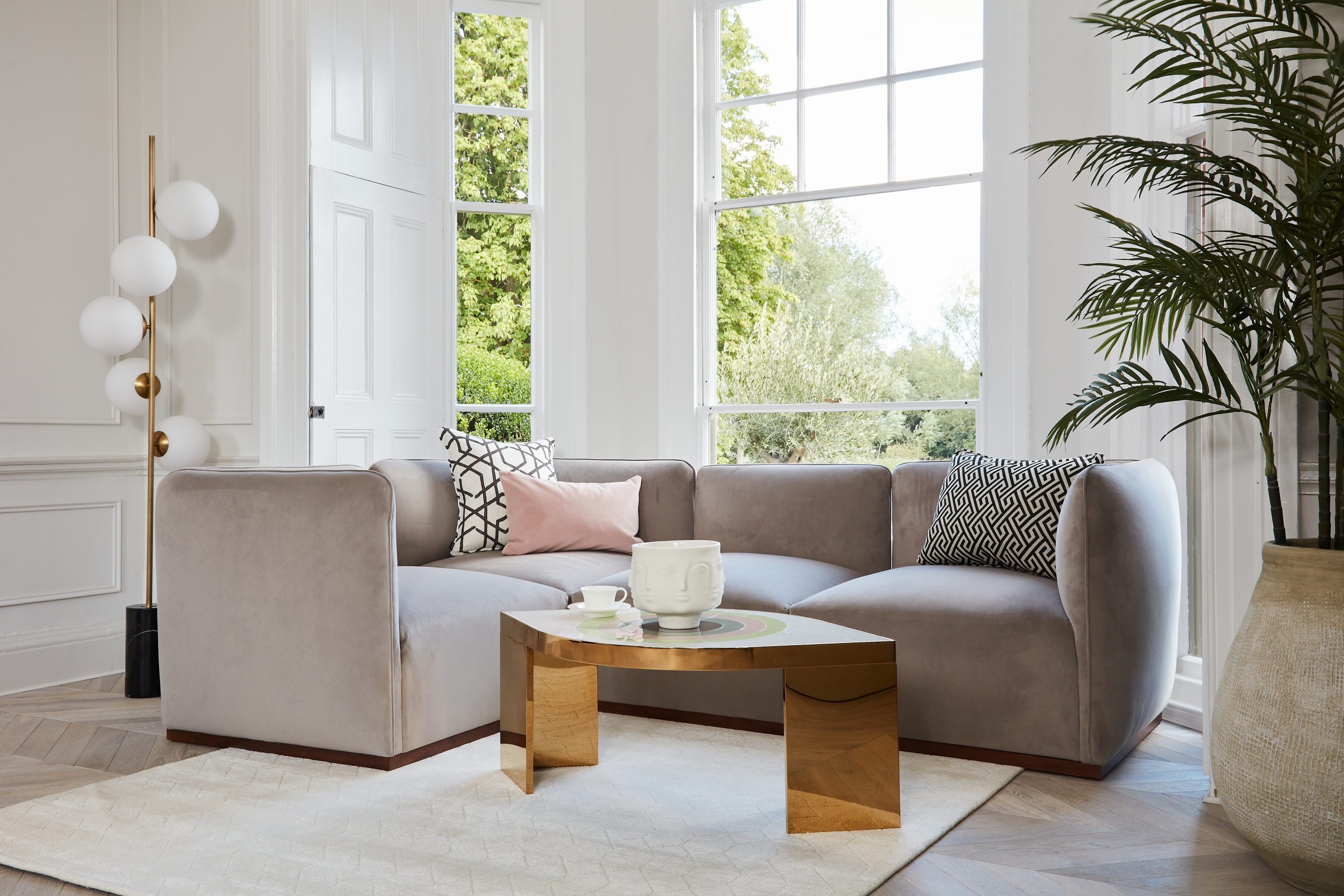 A beautiful grey velvet sofa in a living room lifestyle shot