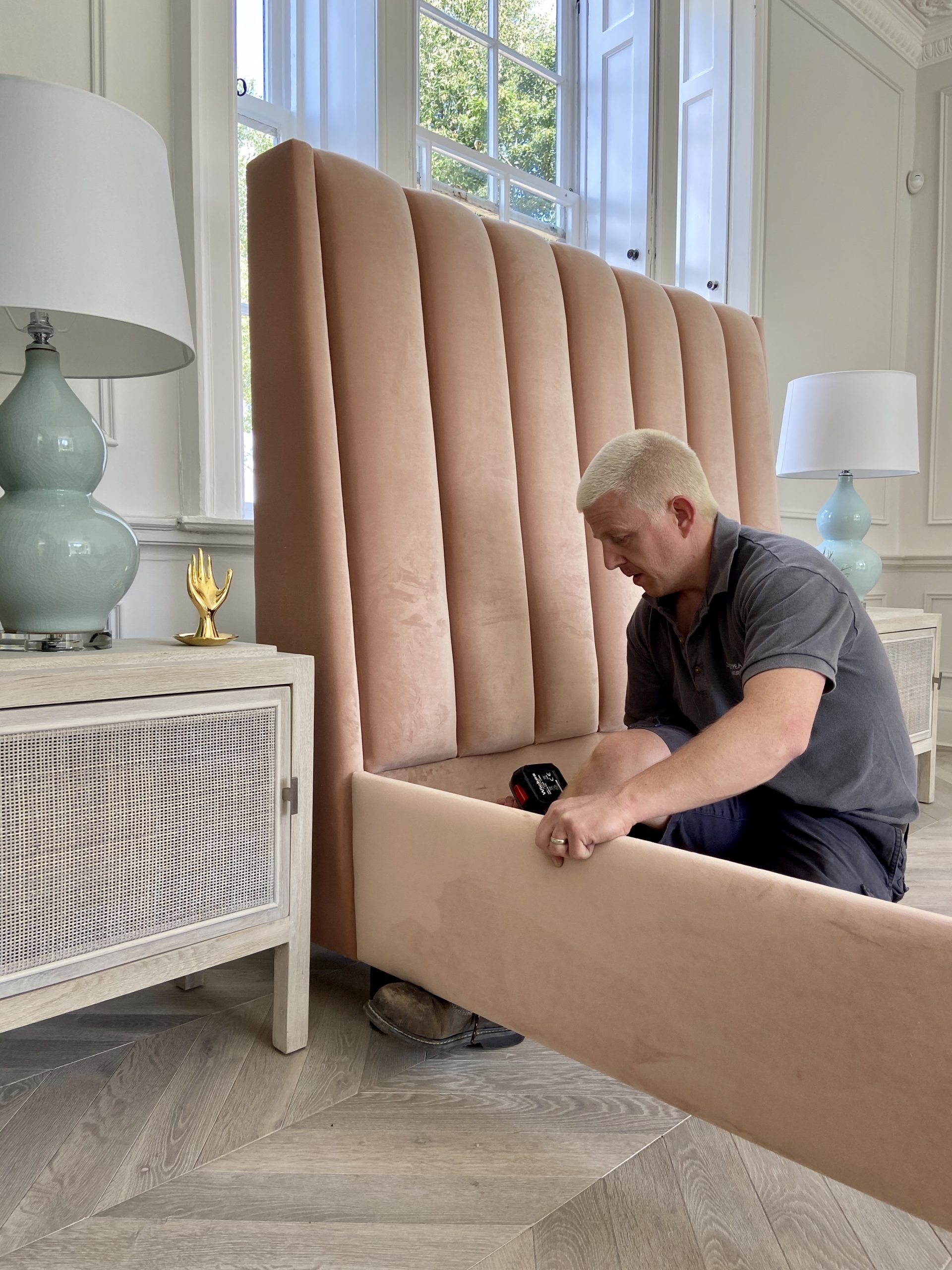 a man assembling a stylish pink bed