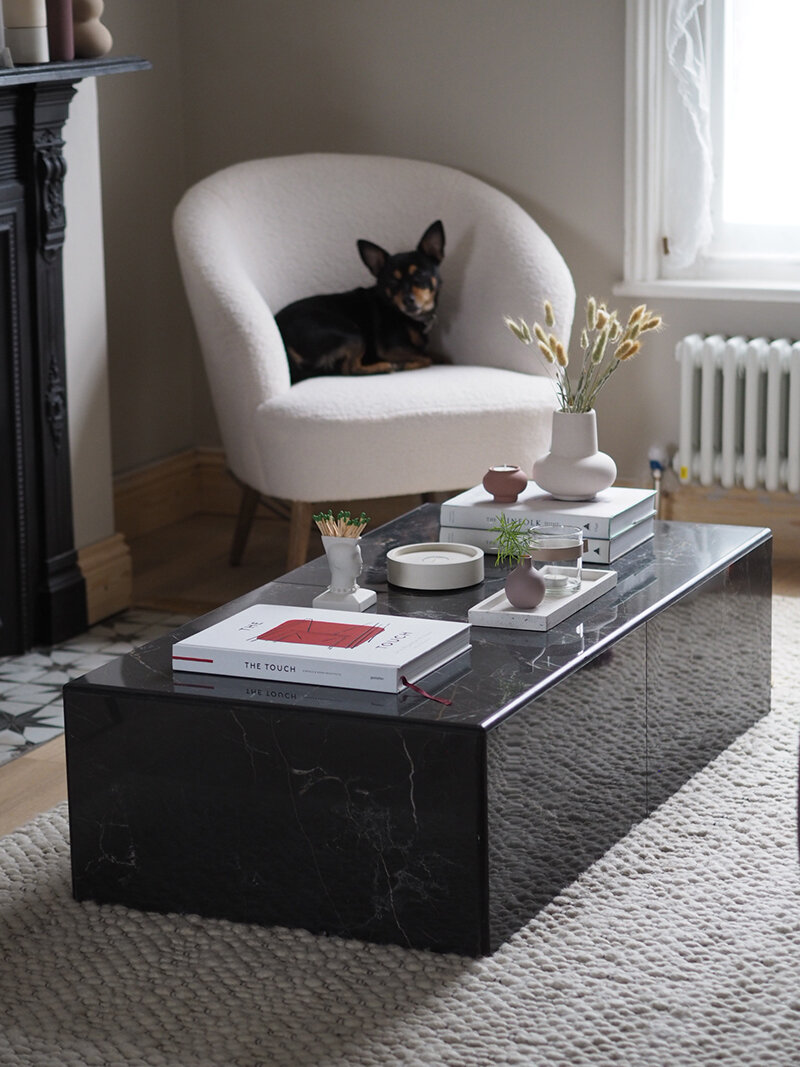 a stylish black marble table in a minimalist living room