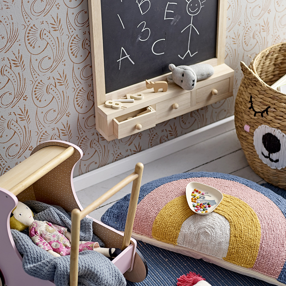 kids accessories in kids playroom: cushion, pram, doll, basket, chalkboard