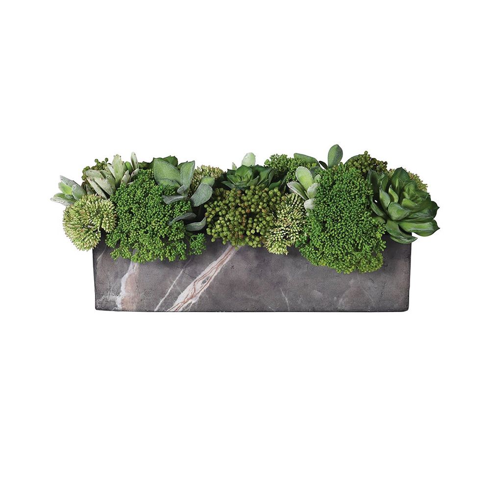 a green botanical arrangement with a grey marble pot