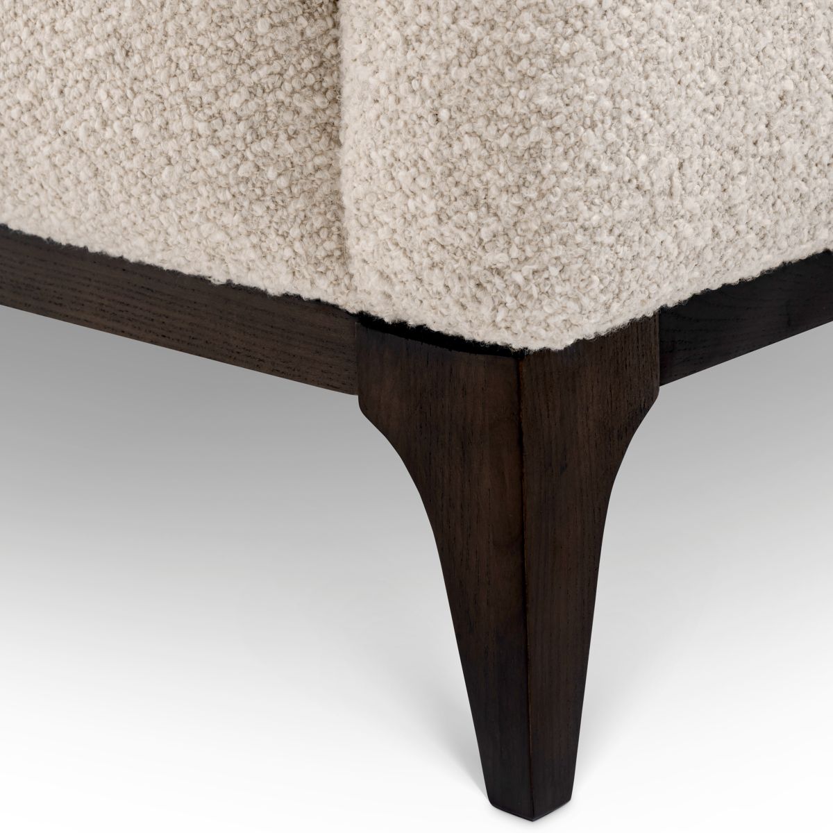 Sleek sofa in boucle cream finish with contrasting black base.