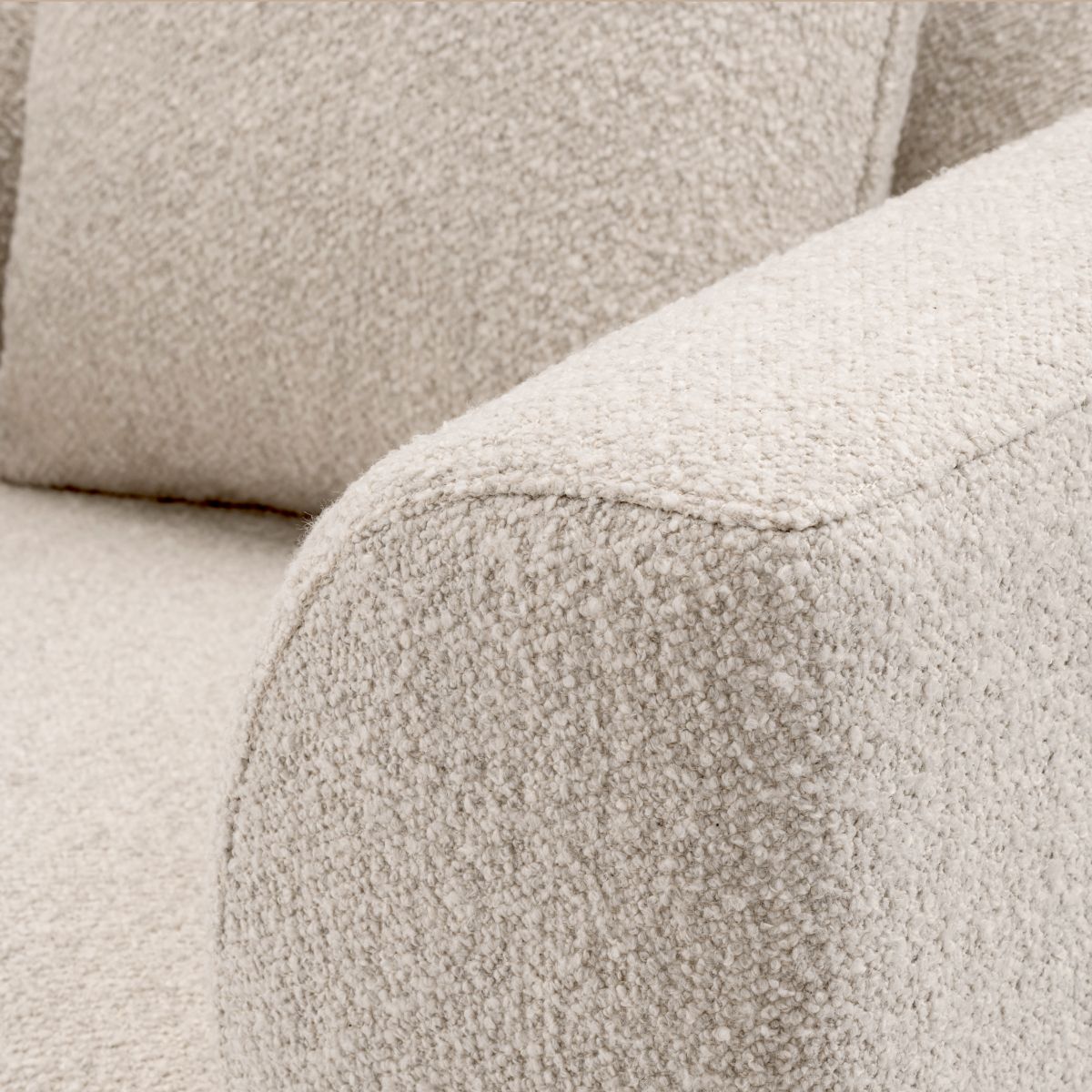 Sleek armchair in boucle cream finish with contrasting black base.