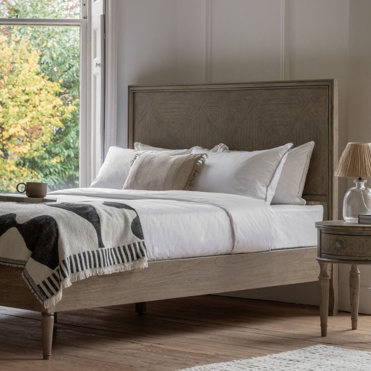 Light wooden king size bed with cross pattern on headboard