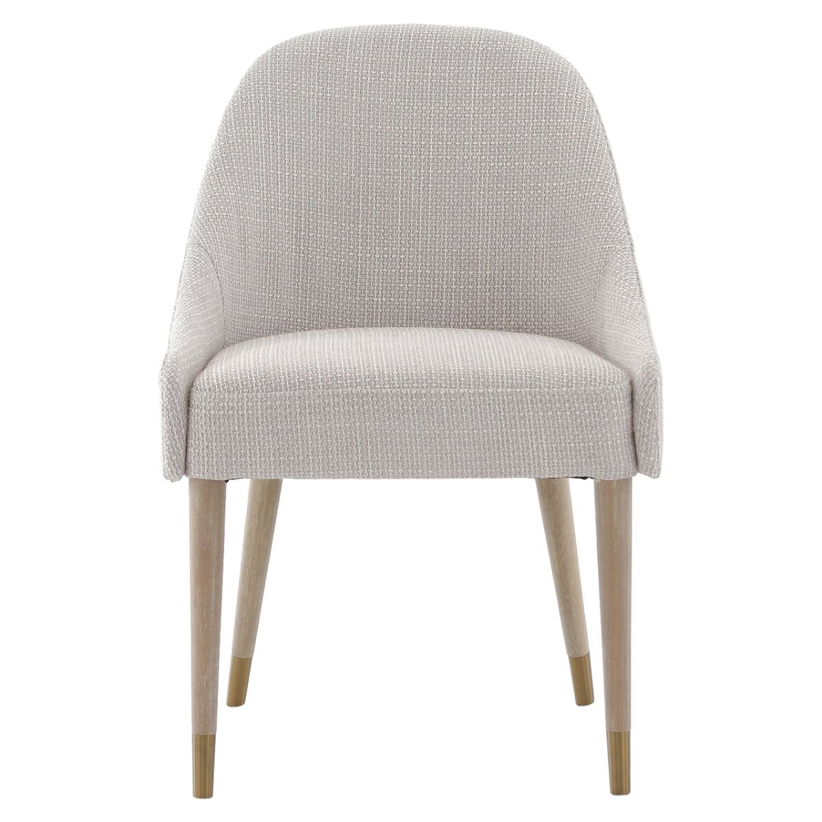 The Bibury Dining Chair features sleek sloped arms, a rounded frame, and solid wood legs with brass golden caps, providing both comfort and style.