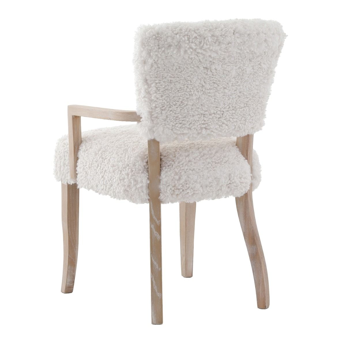 The Winnie Dining Armchair, with its faux sheepskin upholstery and solid oak frame, adds Alpine elegance and comfort, featuring solid oak arms for added support.