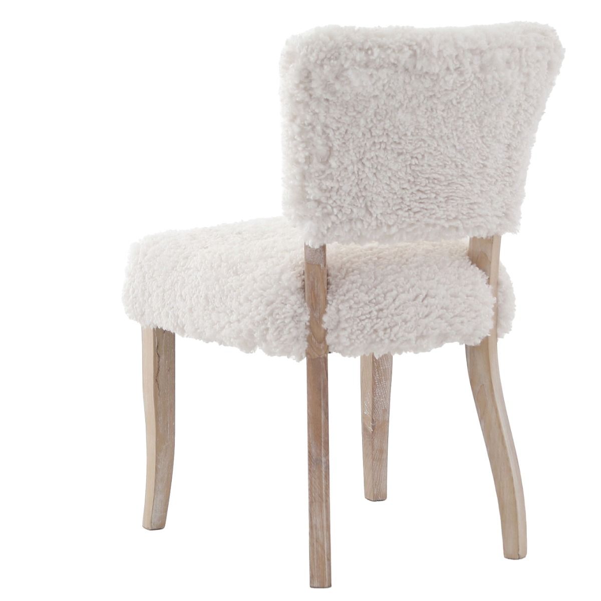 The Winnie Dining Chair, upholstered in faux sheepskin and set on a solid oak frame, brings Alpine charm and style to your dining room.
