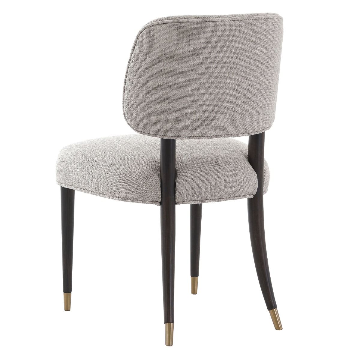 The Cheltenham Dining Chair, upholstered in luxurious linen with a solid oak frame and brass-capped feet, adds timeless elegance to any dining table.