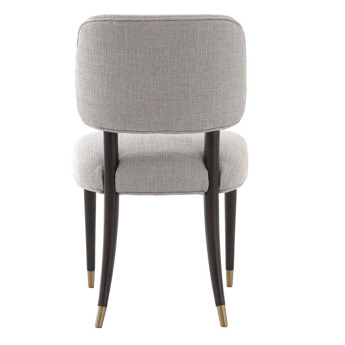 The Cheltenham Dining Chair, upholstered in luxurious linen with a solid oak frame and brass-capped feet, adds timeless elegance to any dining table.