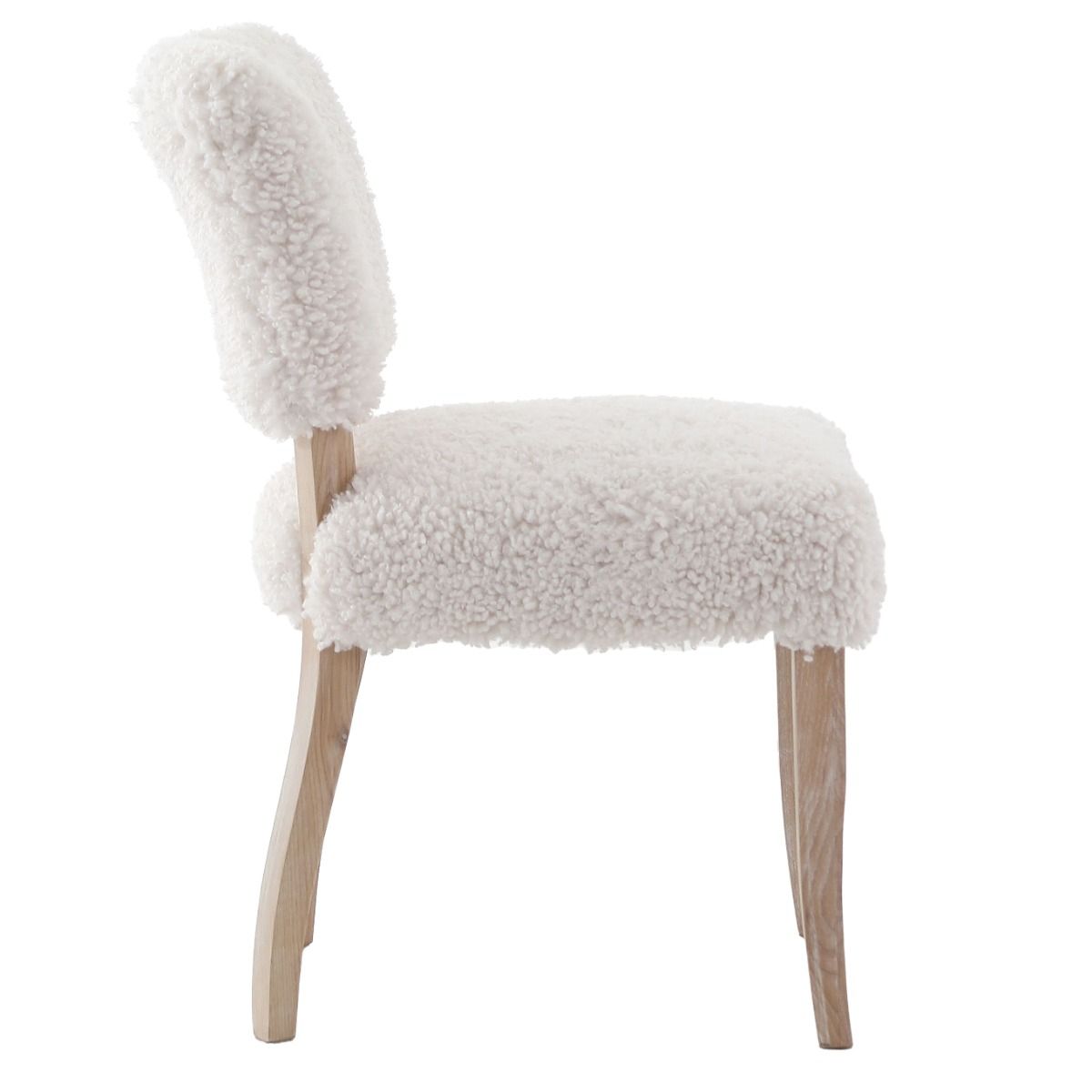 The Winnie Dining Chair, upholstered in faux sheepskin and set on a solid oak frame, brings Alpine charm and style to your dining room.