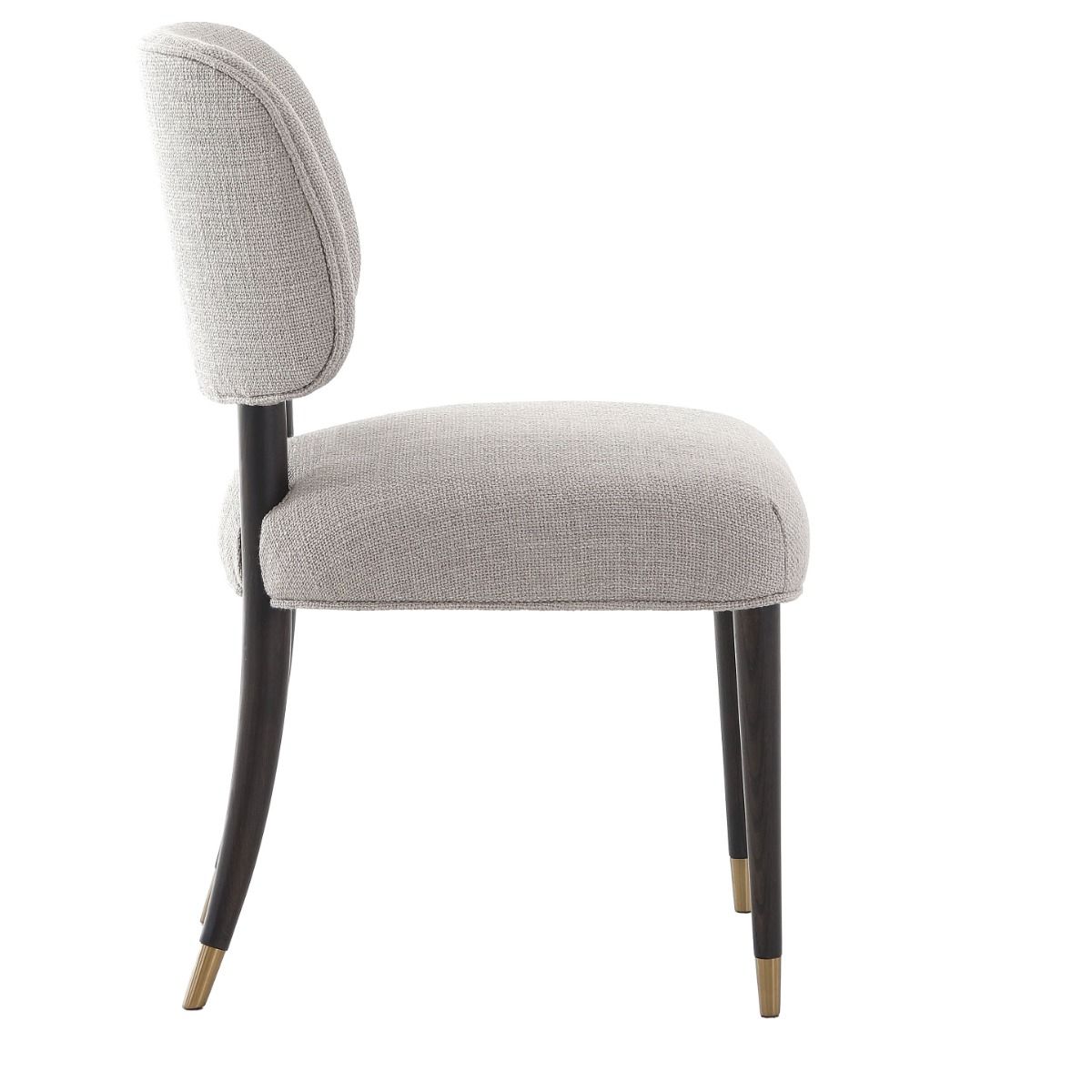The Cheltenham Dining Chair, upholstered in luxurious linen with a solid oak frame and brass-capped feet, adds timeless elegance to any dining table.