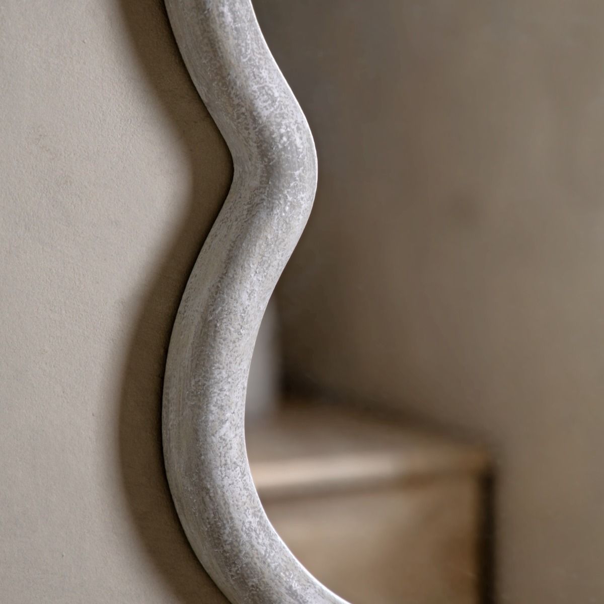 Wall mirror with a wavy edge detailing