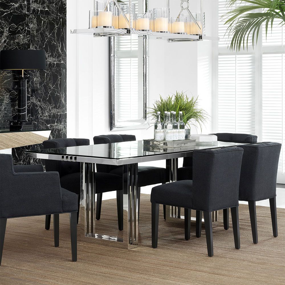 contemporary dining table with a transparent surface and stainless steel frame