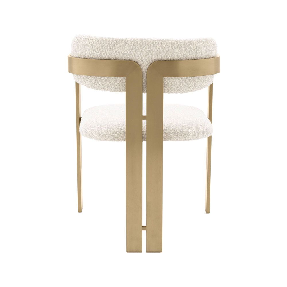 A chic and contemporary brushed brass dining chair upholstered in boucle fabric 