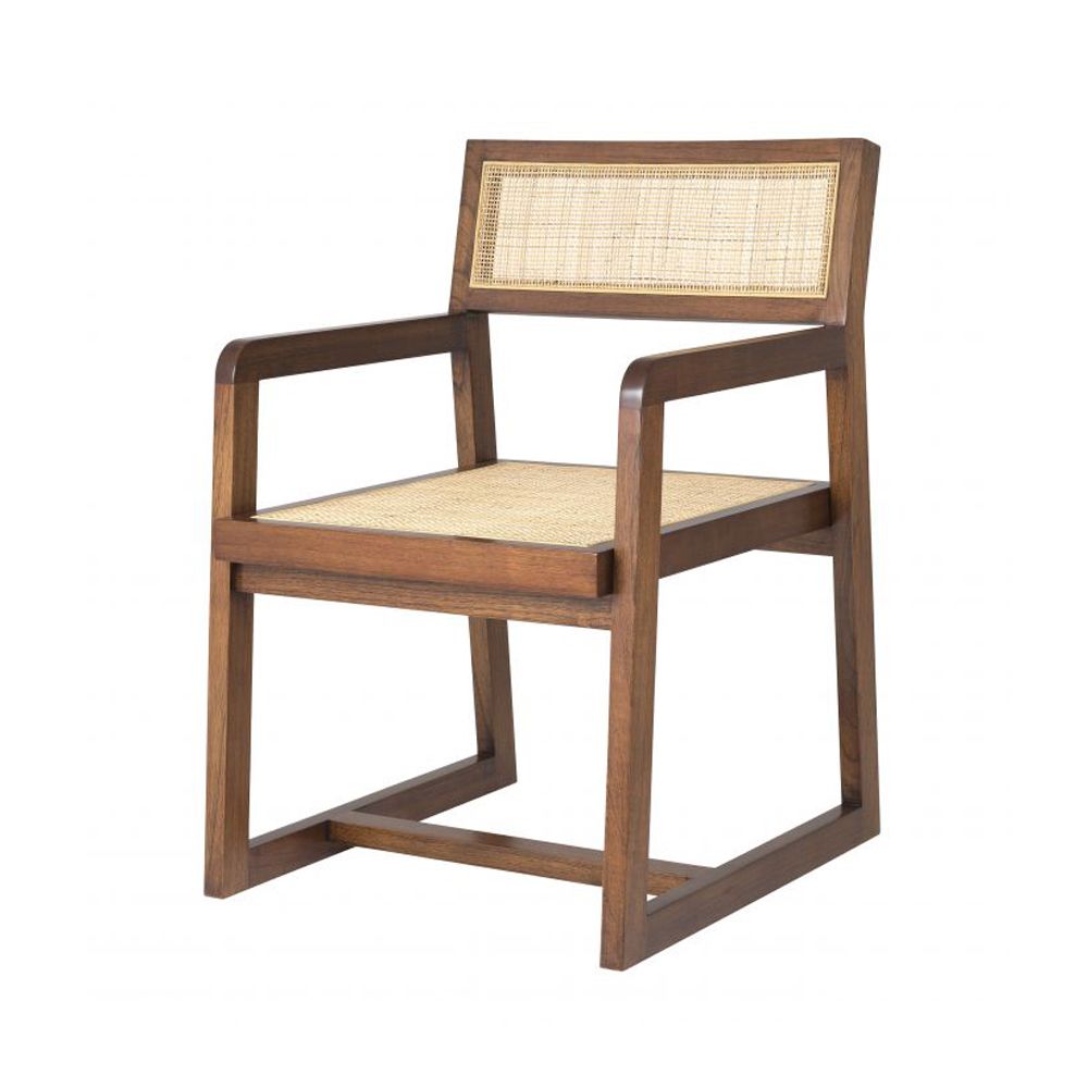 A luxurious rattan dining chair with a painted black finish and armrests