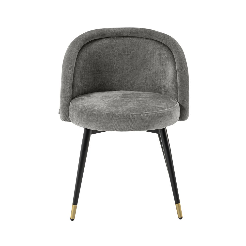 A luxurious set of two velvet dining chairs with black tapered legs and golden caps