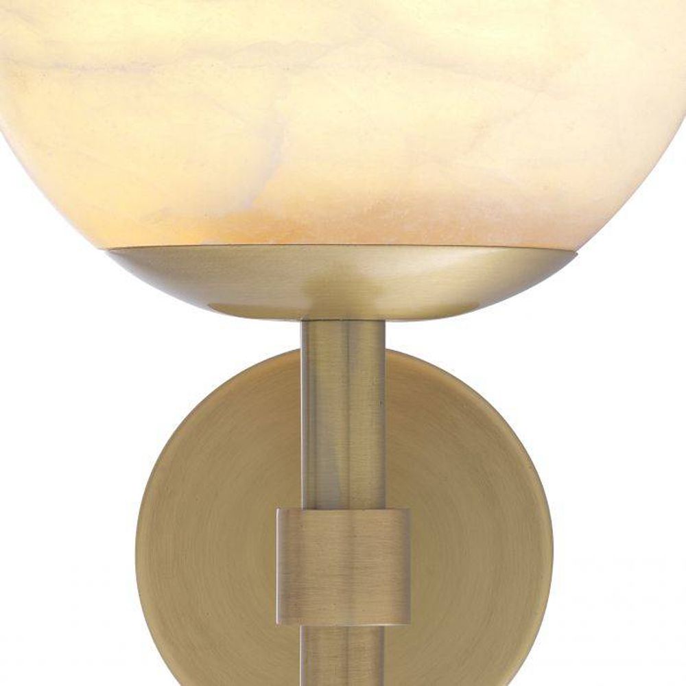 A luxurious antique brass wall lamp with an elegant, alabaster shade
