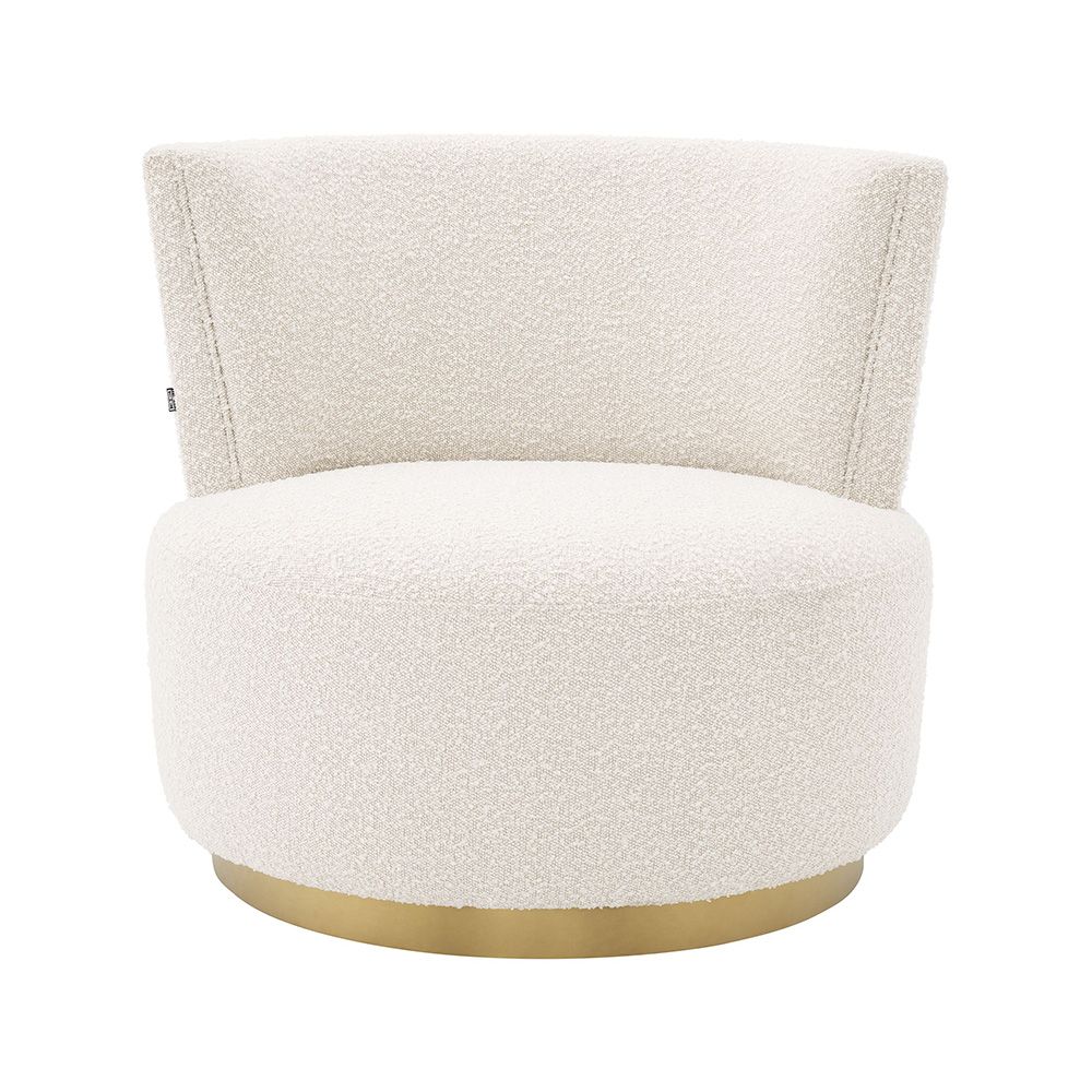 A beautiful armchair with boucle upholstery and a brushed brass swivel base