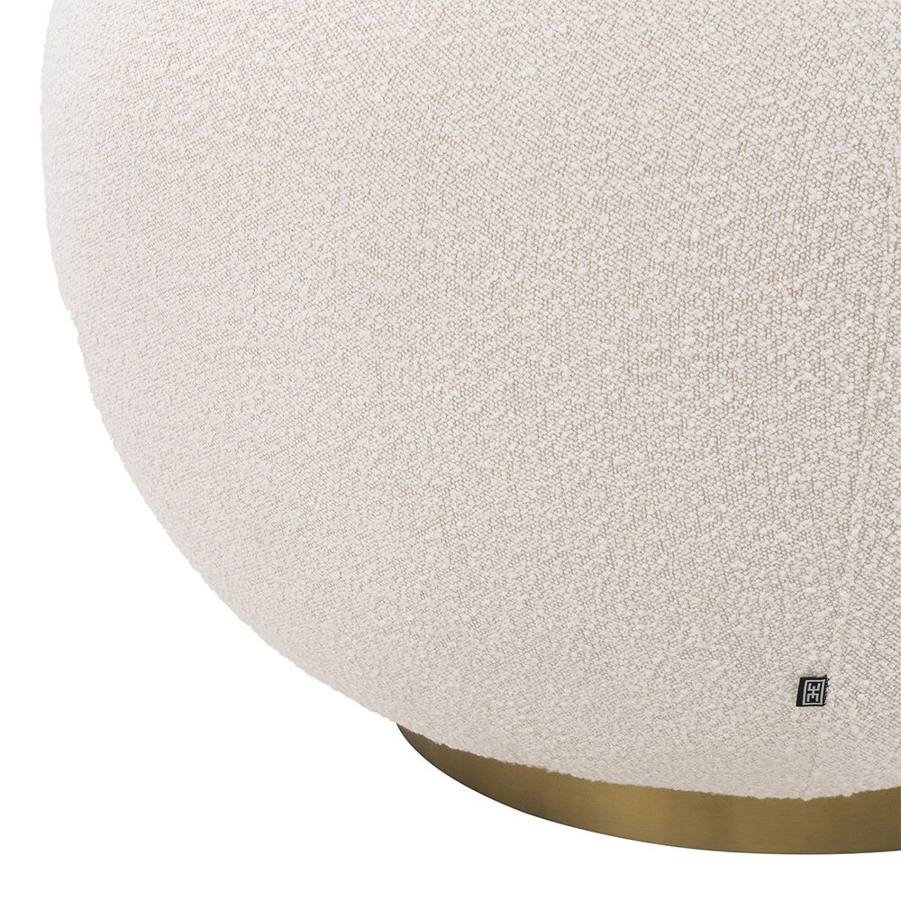 A sumptuous swivel chair by Eichholtz with a chic circular design, beautiful boucle cream upholstery and glamorous brushed brass base