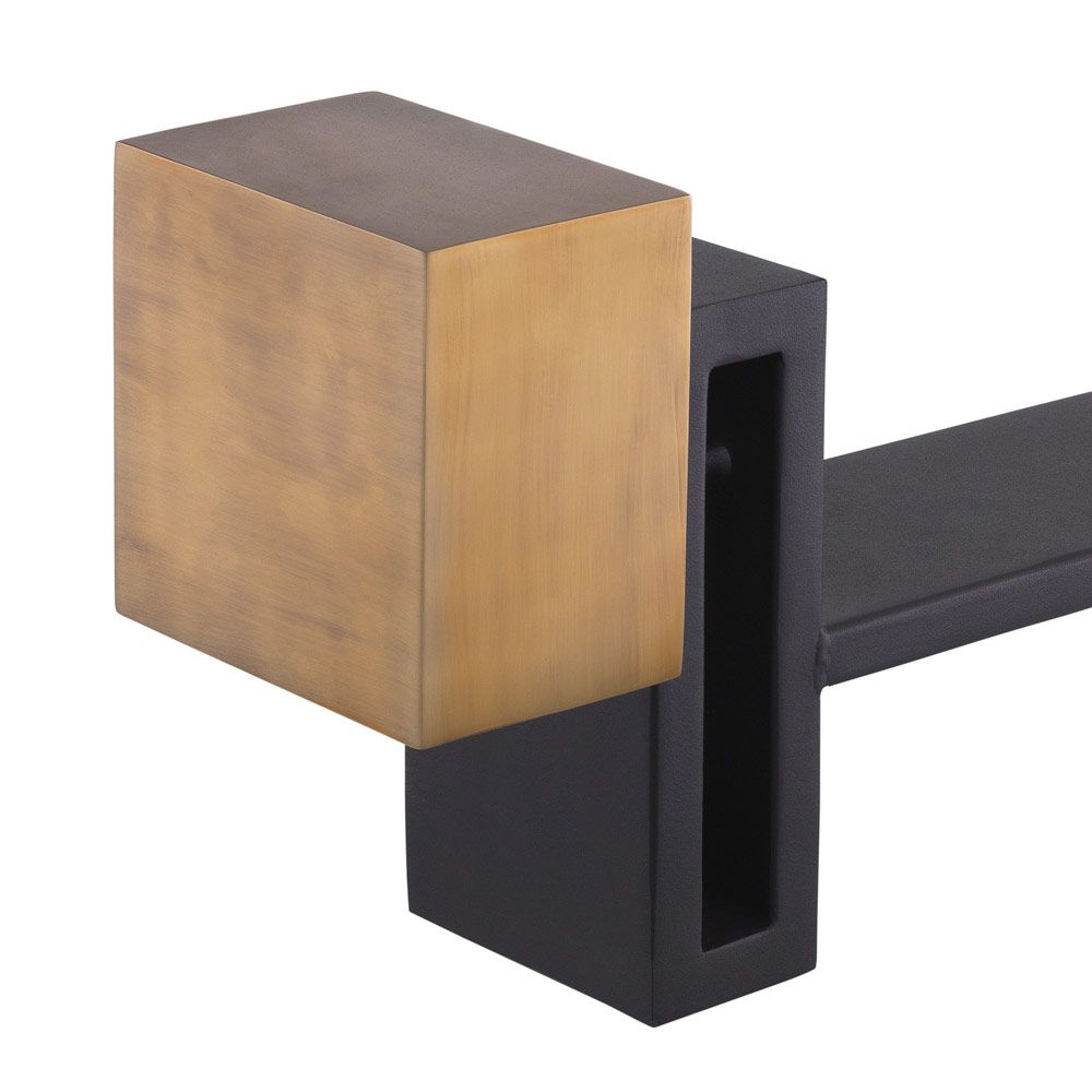 A luxury set of andirons by Eichholtz which feature vintage brass blocks and a black finish