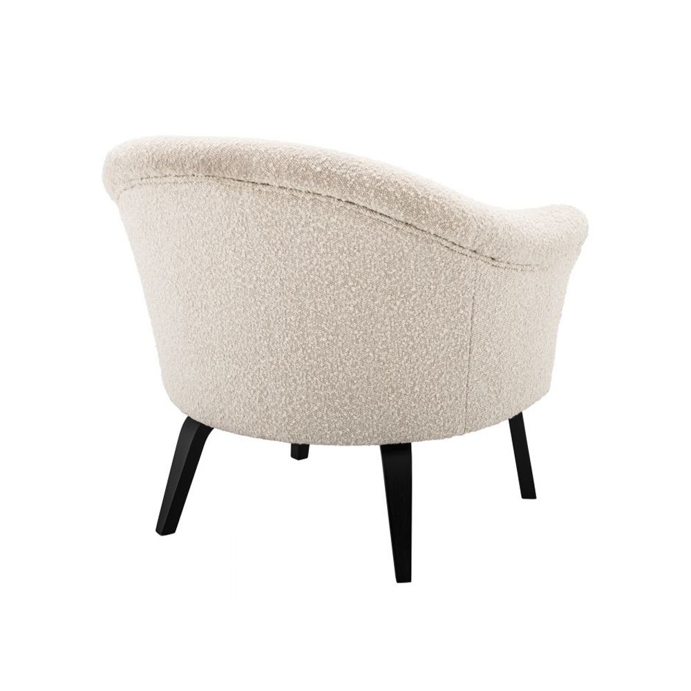 A luxurious boucle cream upholstered chair by Eichholtz with a curved silhouette and black bentwood legs
