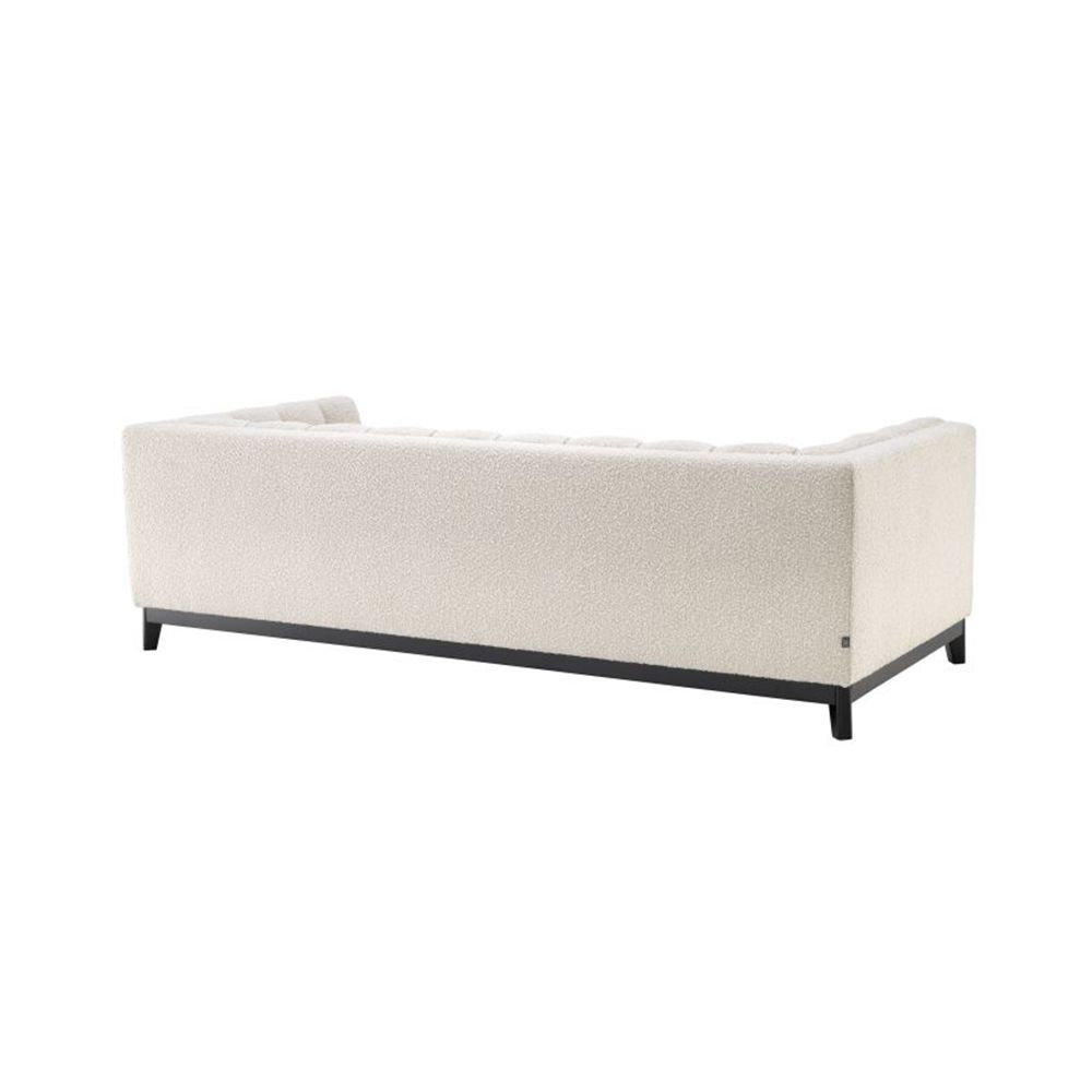 A cosy and luxurious boucle cream sofa with a contrasting black finish base by Eichholtz 