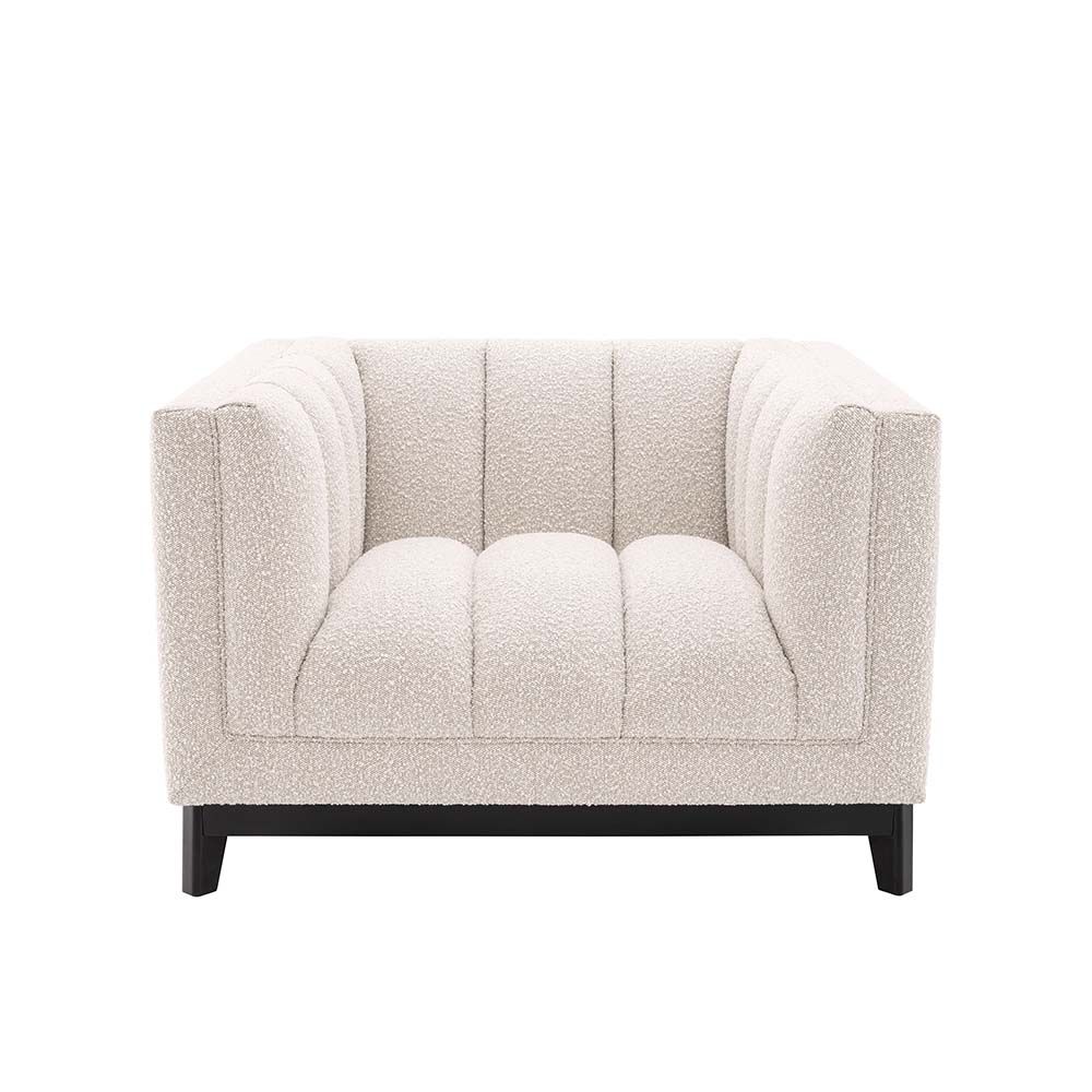 A luxurious boucle armchair in a creamy white upholstery with black legs