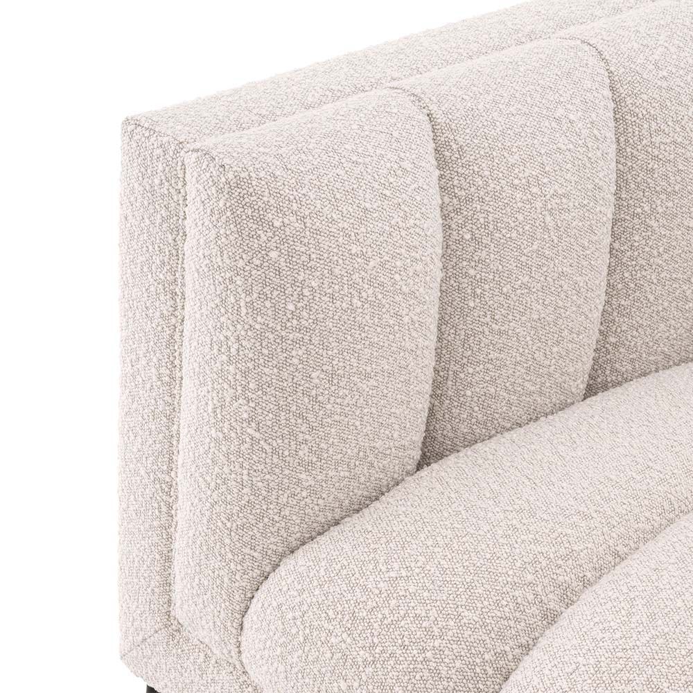 A luxurious boucle armchair in a creamy white upholstery with black legs