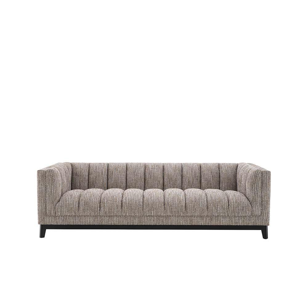 A gorgeous rustic inspired sofa upholstered in a beige fabric with black features.