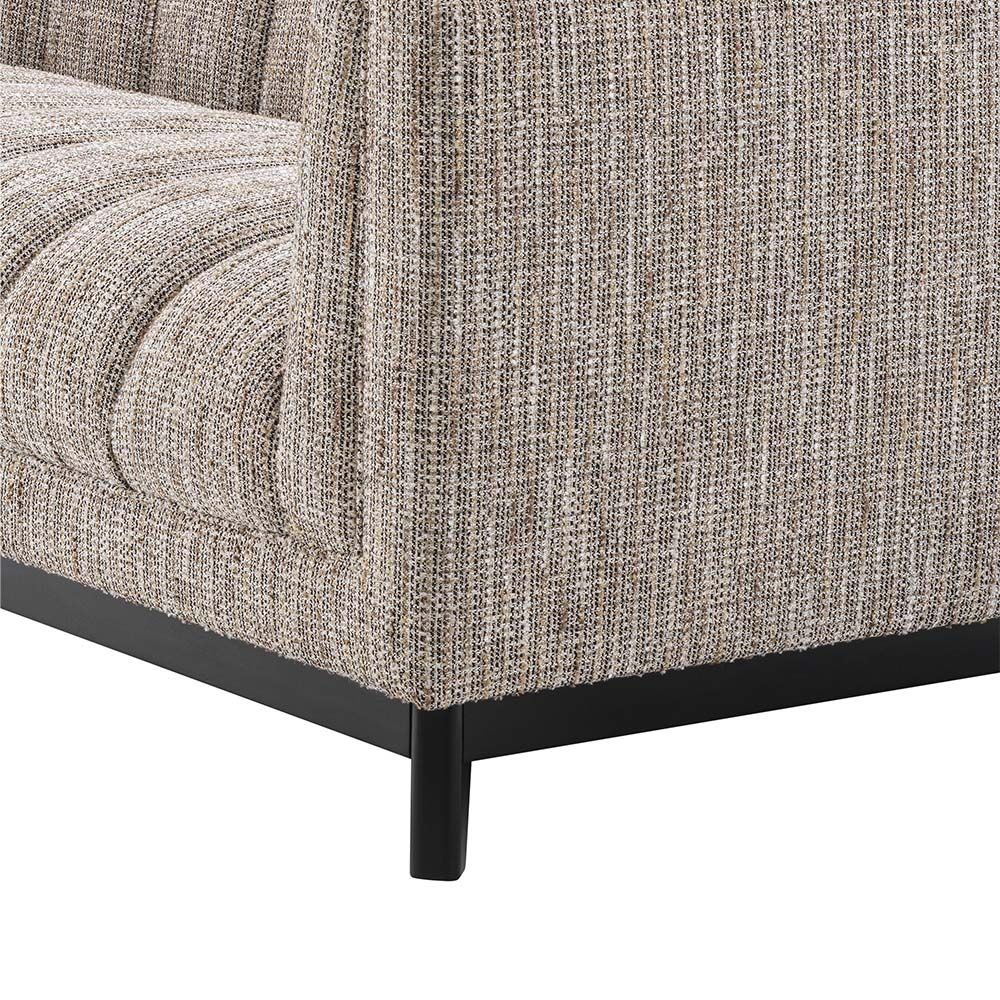 A gorgeous rustic inspired sofa upholstered in a beige fabric with black features.
