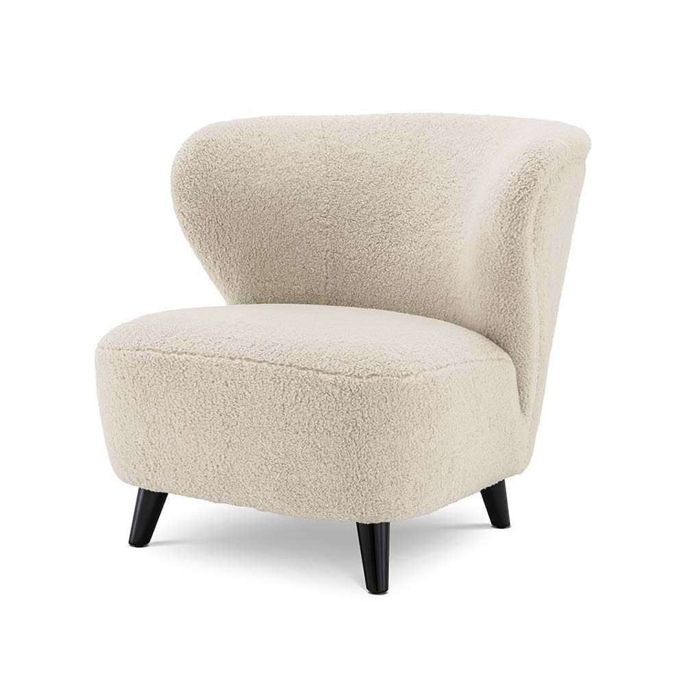 A decadent accent chair in a cream upholstery with contrasting black legs