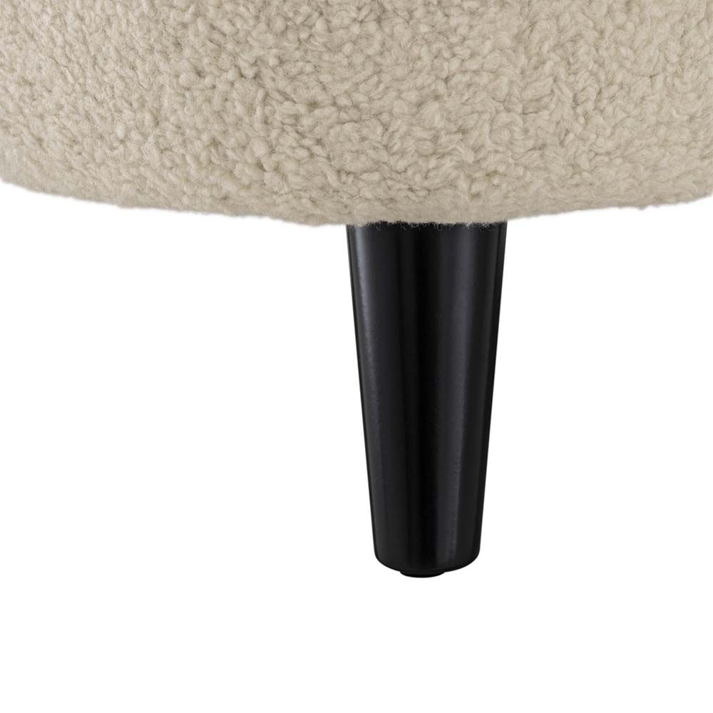 A decadent accent chair in a cream upholstery with contrasting black legs