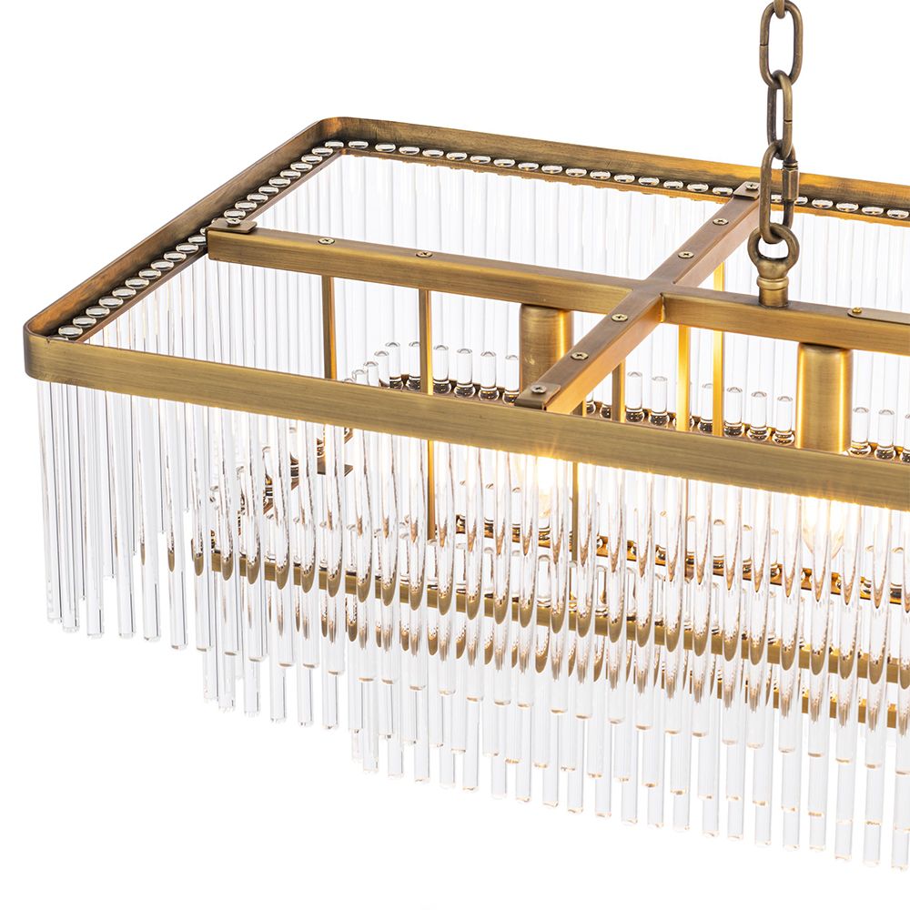 A captivating, Art Deco inspired chandelier by Eichholtz with three levels of clear glass rods and an antique brass finish