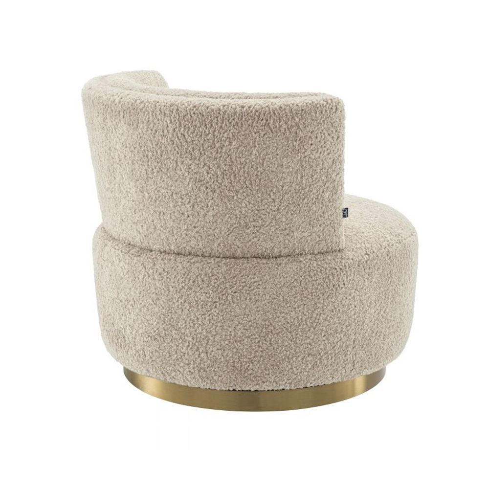 A luxuriously soft curvaceous swivel chair by Eichholtz with a brushed brass swivel base