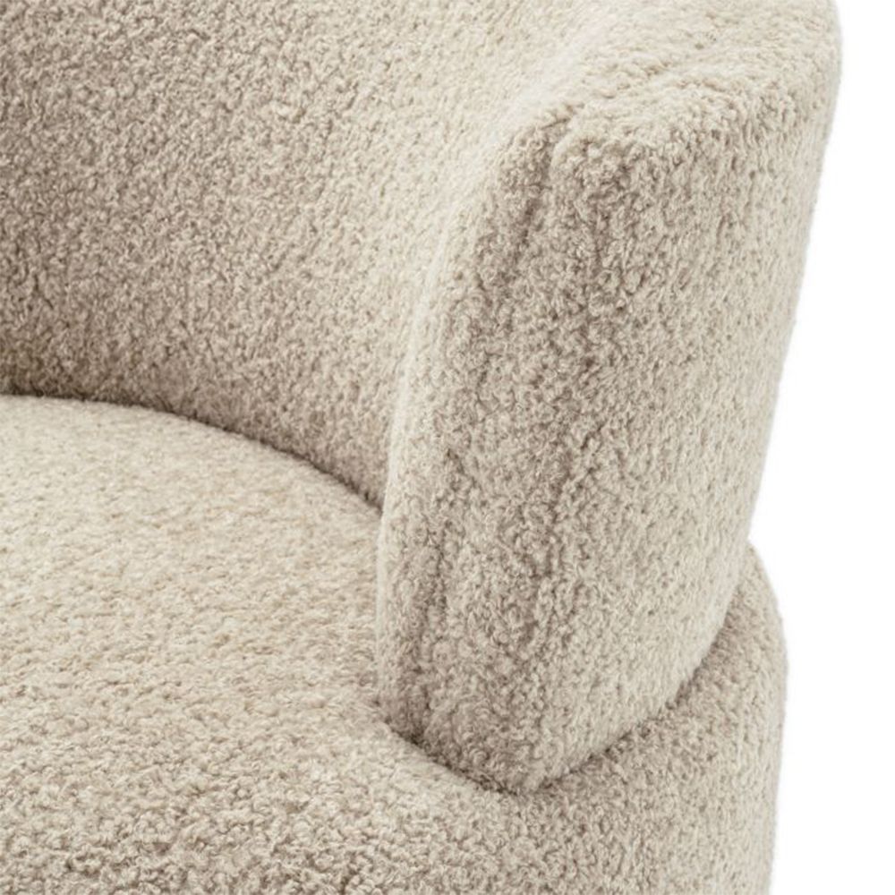 A luxuriously soft curvaceous swivel chair by Eichholtz with a brushed brass swivel base