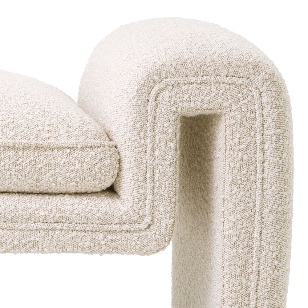 A luxurious bench by Eichholtz with a unique, free flowing design and bouclé cream upholstery