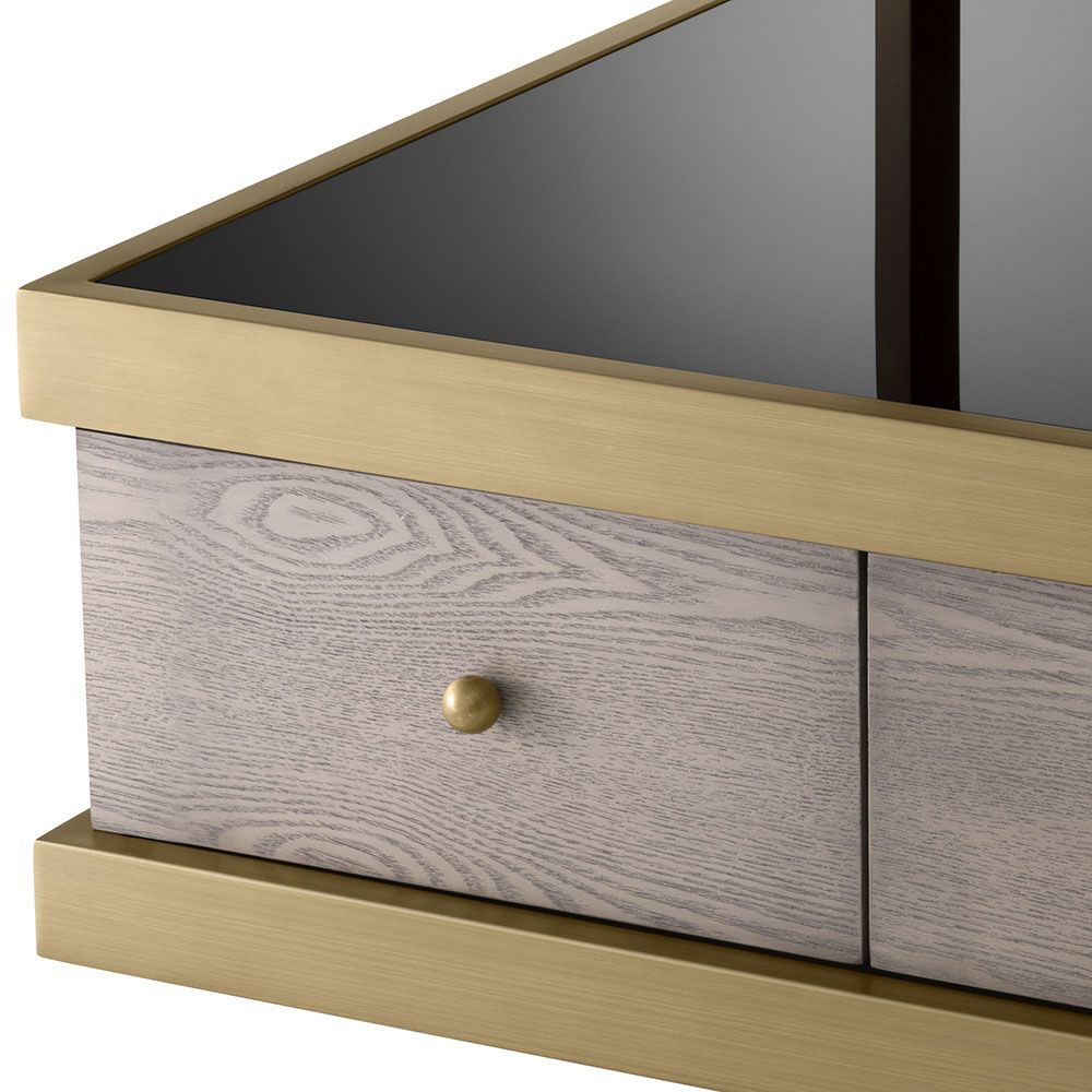 A sophisticated side table by Eichholtz which doubles up as a stylish storage solution with a brass frame and black glass finish