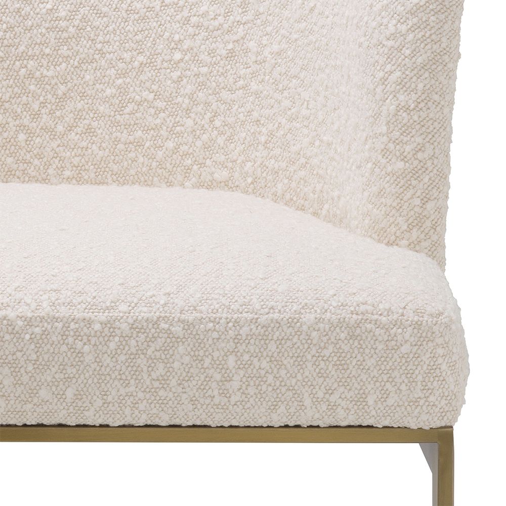 Modern, boucle upholstered dining chair with brushed brass base