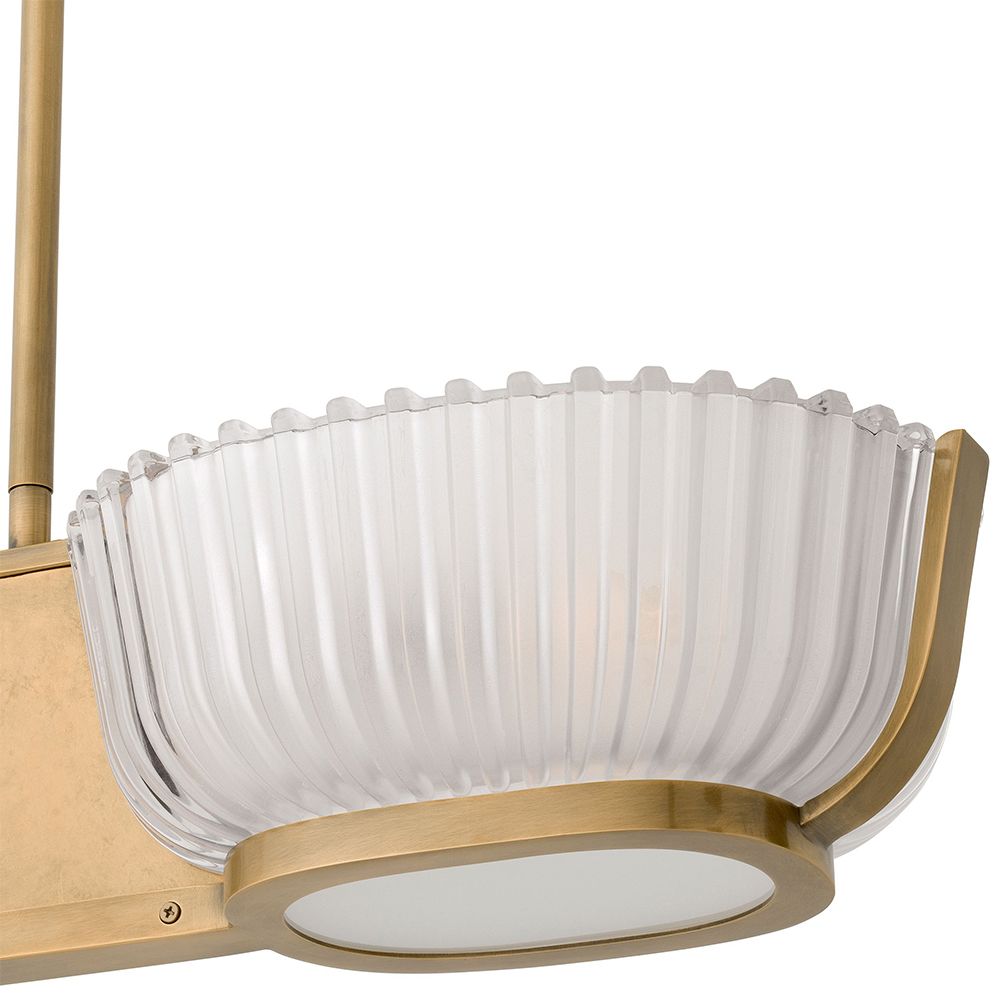 An elegant chandelier by Eichholtz with a vintage brass finish and frosted glass shades