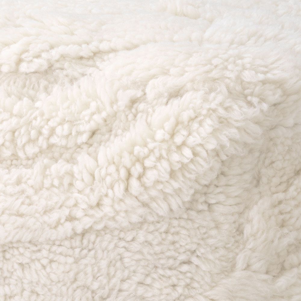 Cosy wool pouffe with elegant flowing curves