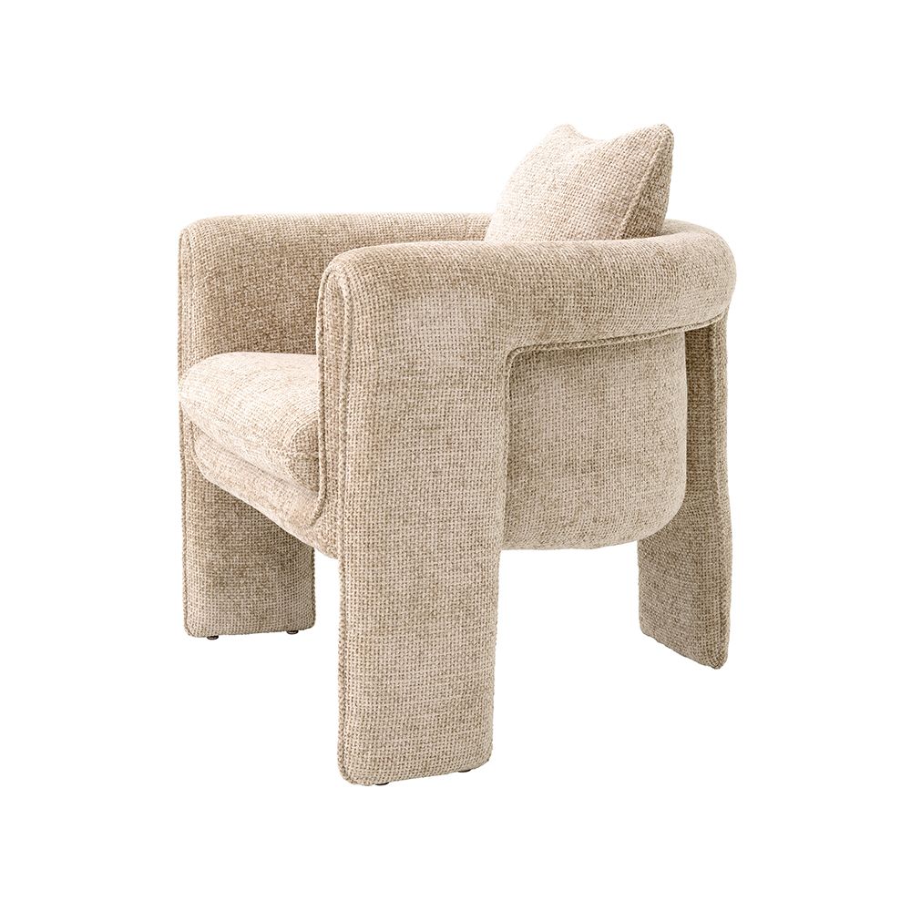 A curvaceous armchair with a contemporary chic upholstery and complementary scatter cushion