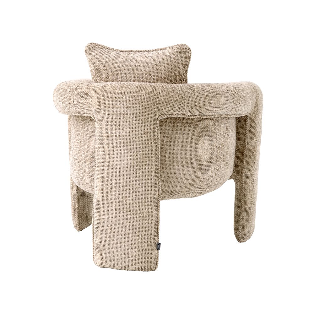 A curvaceous armchair with a contemporary chic upholstery and complementary scatter cushion