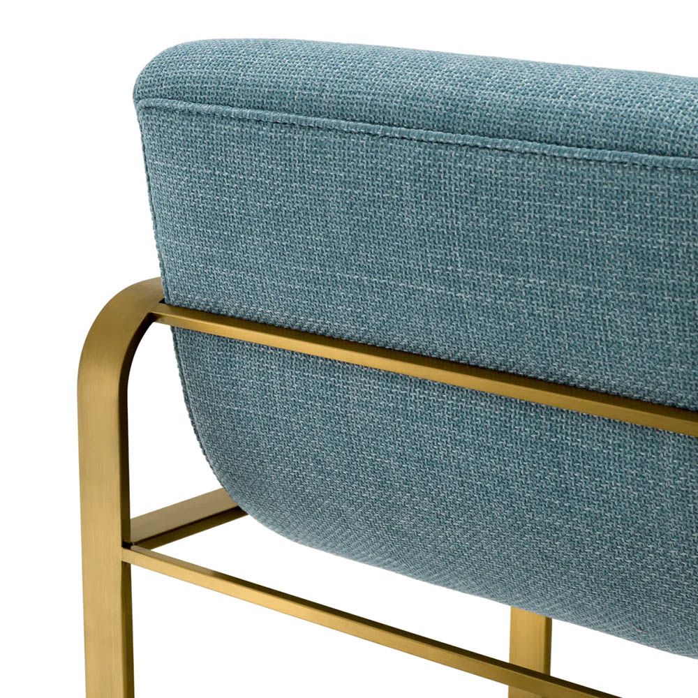 blue linen upholstered counter stool with horizontal fluting and brass frame