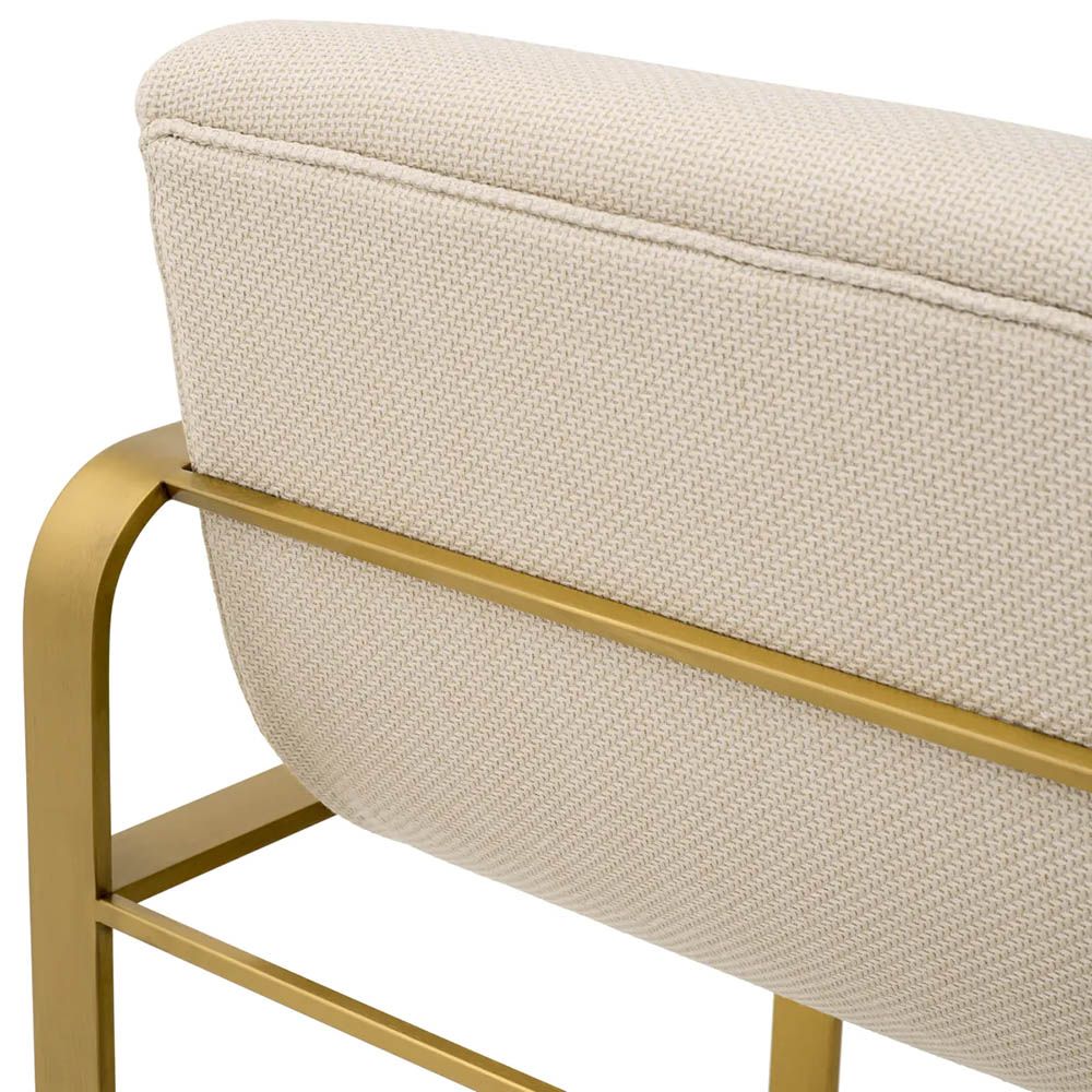 Cream linen upholstered bar stool with horizontal fluting and brass frame