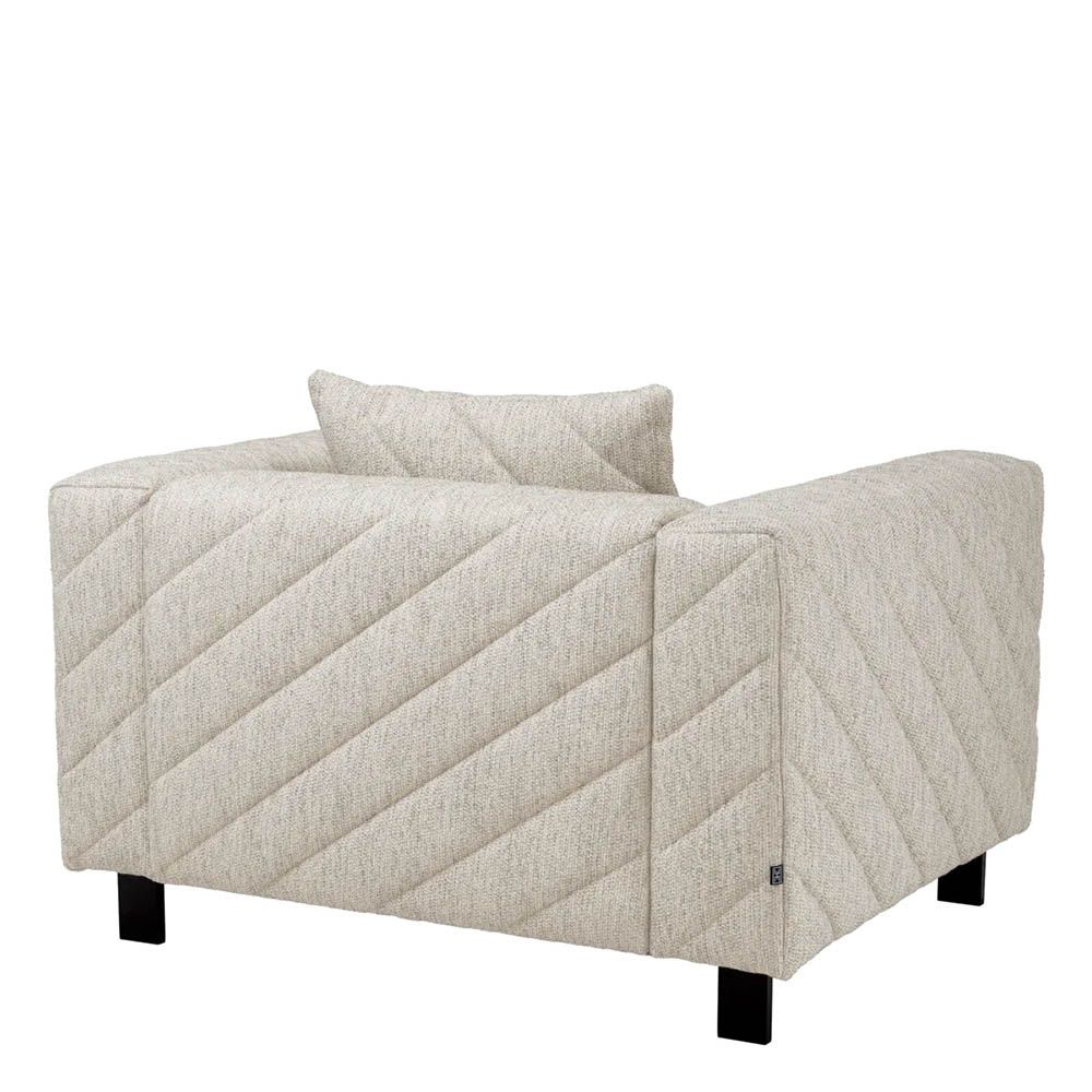Grey upholstered modern armchair with chevron stitching detail