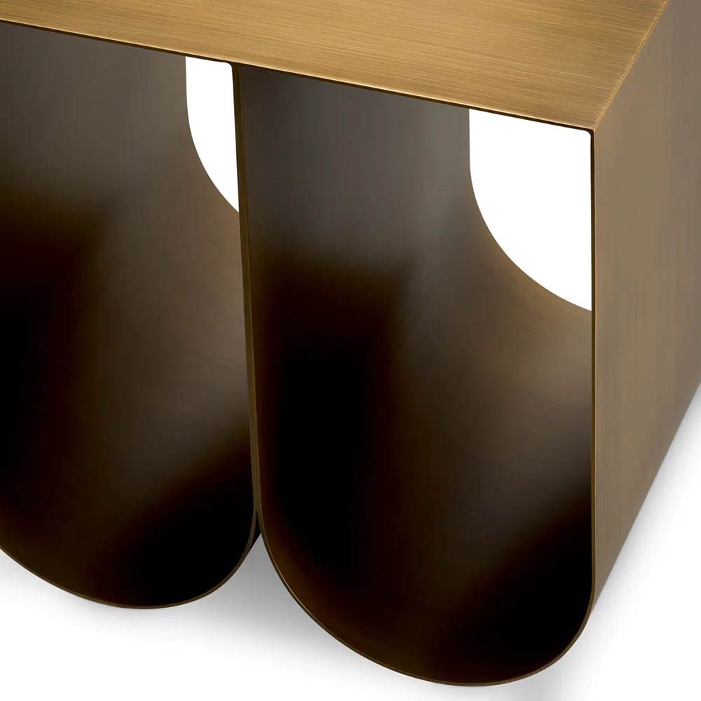 Modern side table with two curved legs finished in brushed brass