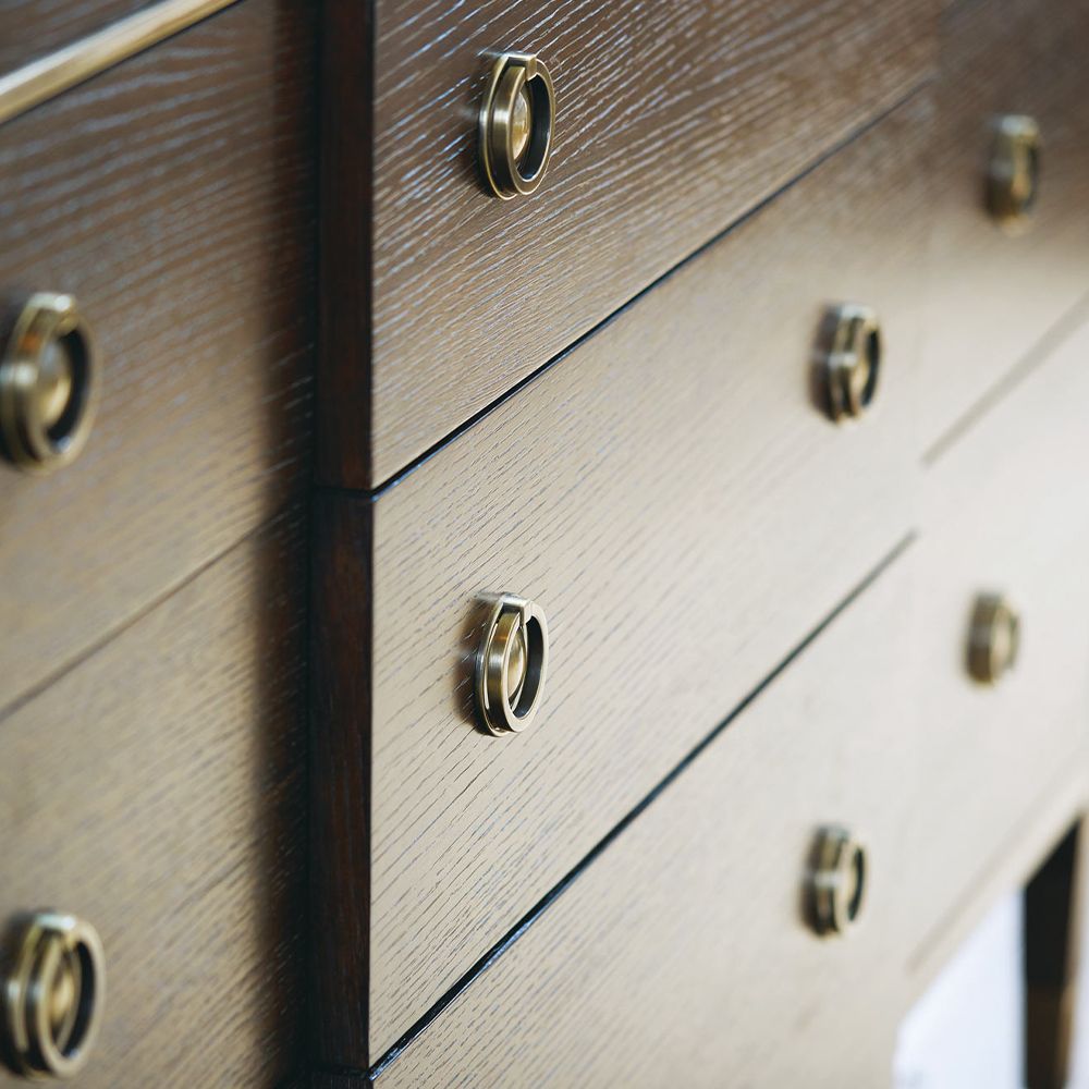 A sophisticated dresser from Bernhardt with a burnished brass and white oak veneer finish, six legs and nine drawers