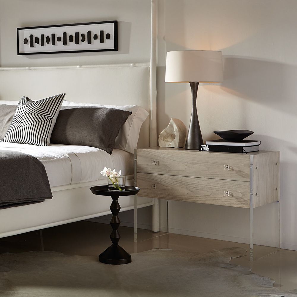 A beautiful two drawer bedside table from Bernhardt featuring a rustic bleached walnut veneer finish and acrylic end panels