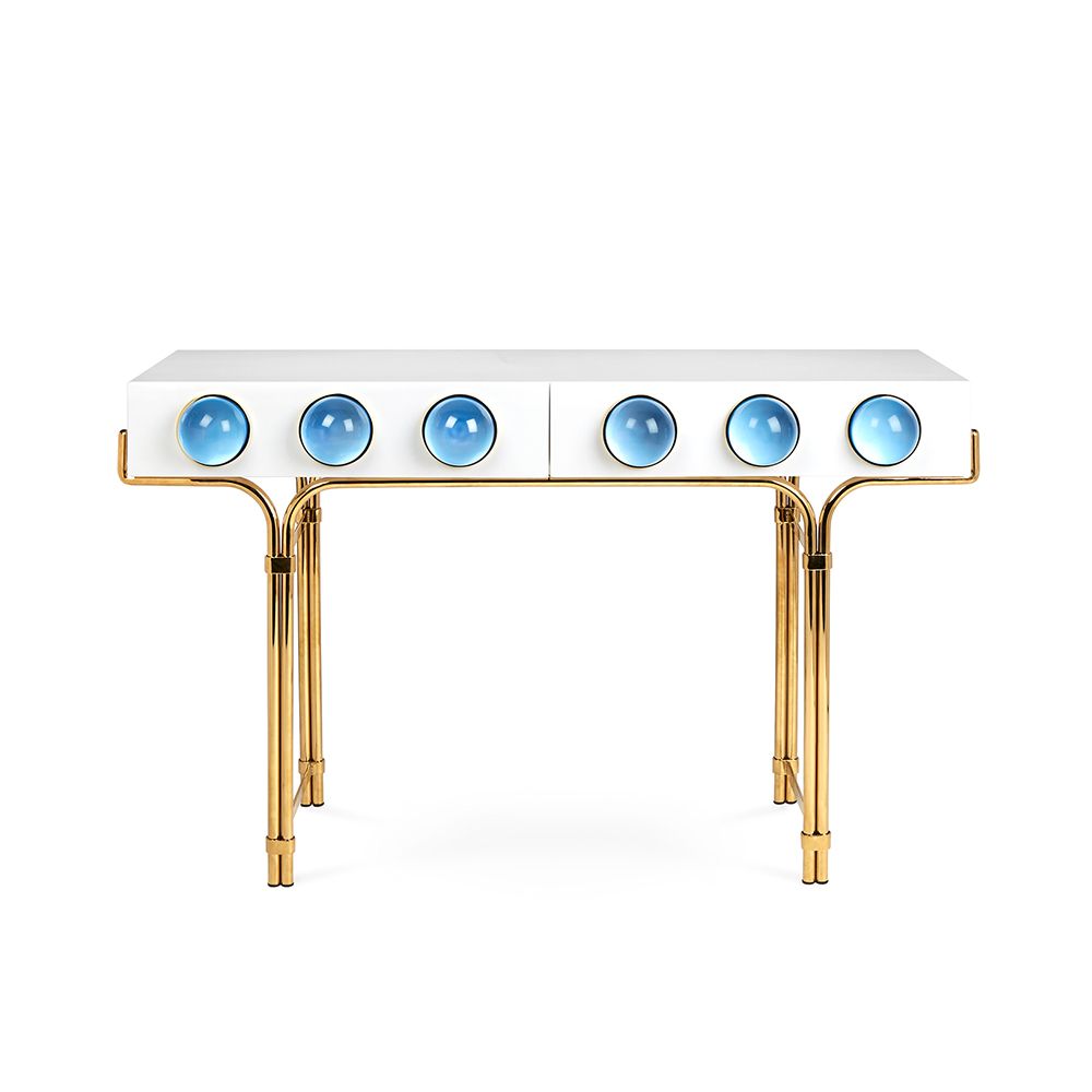 A futuristic white console table with blue acrylic cabochons and a polished brass base 